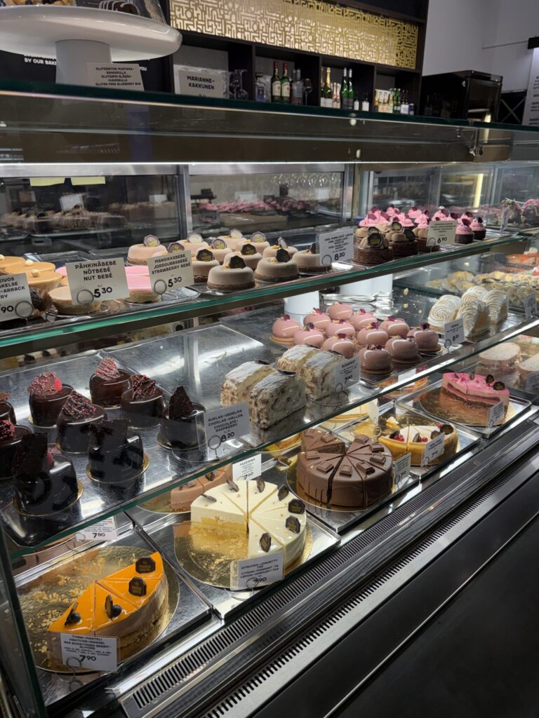 Showcase filled with glossy chocolate cakes and pink mousses at Fazer Cafe