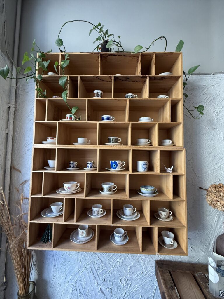 Wooden shelves displaying a neat collection of vintage Nordic cups and saucers.
