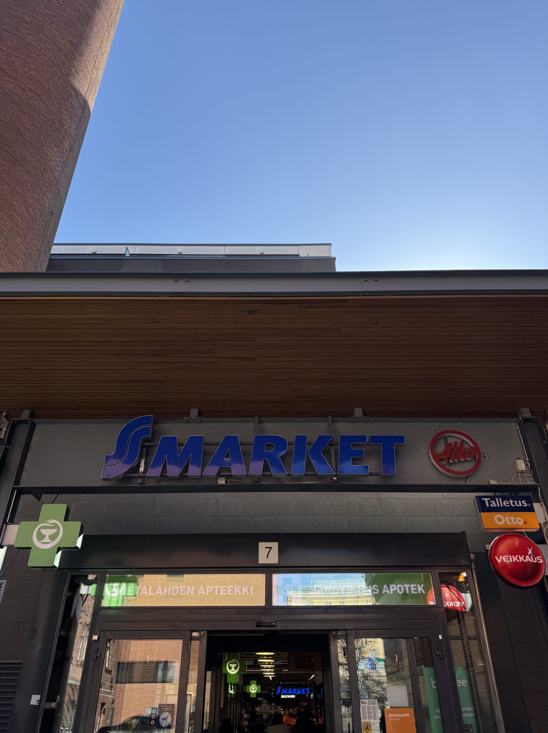 The blue sign of S-MARKET BULEVARDI against a clear blue sky