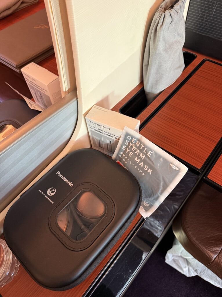 Shiseido Men amenity kit and Panasonic headphones on the side table