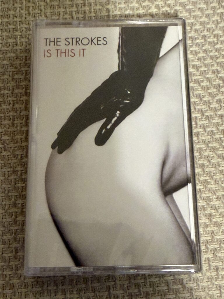 The Strokes cassette resting on woven fabric at home