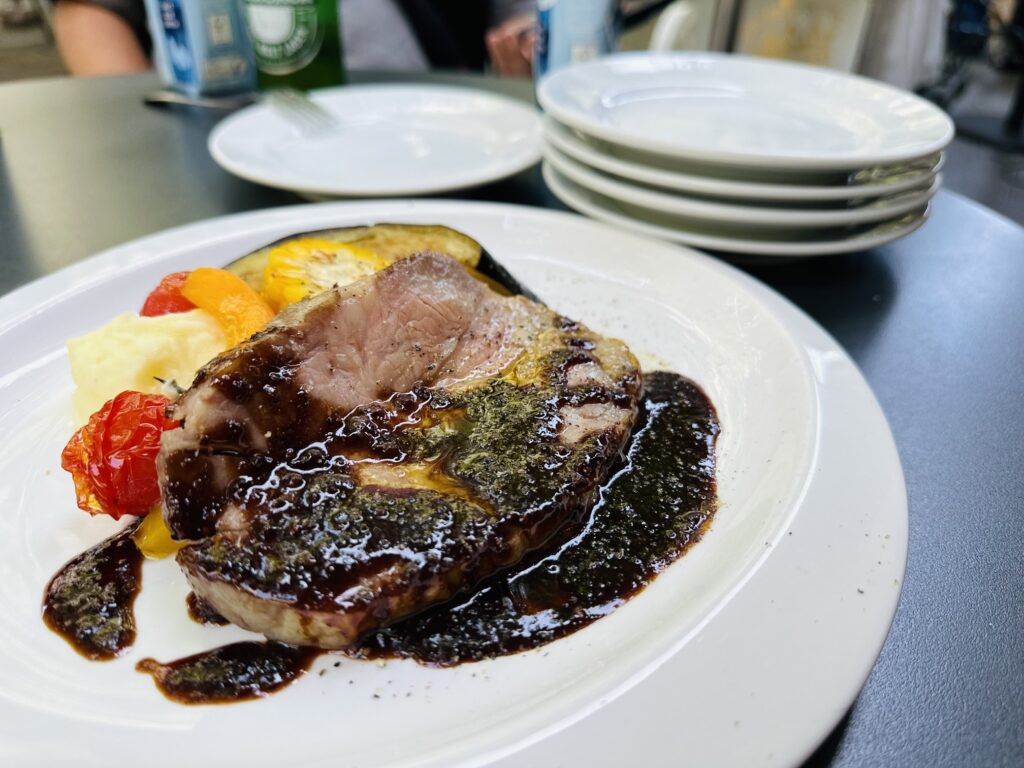 Thick slice of beef with dark sauce and mashed potatoes