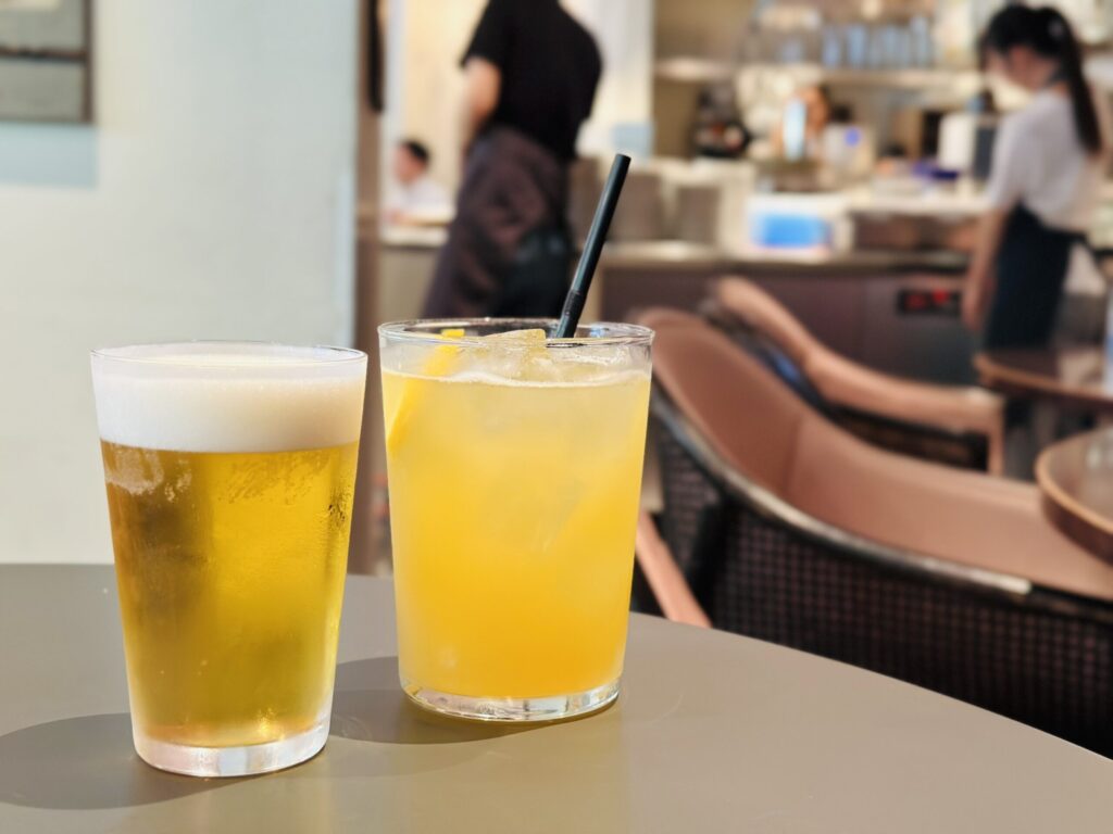 Draft beer and orange beverage on the outdoor table