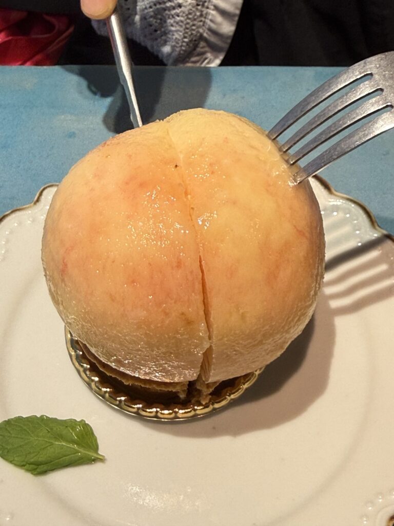 Knife cutting into peach tart