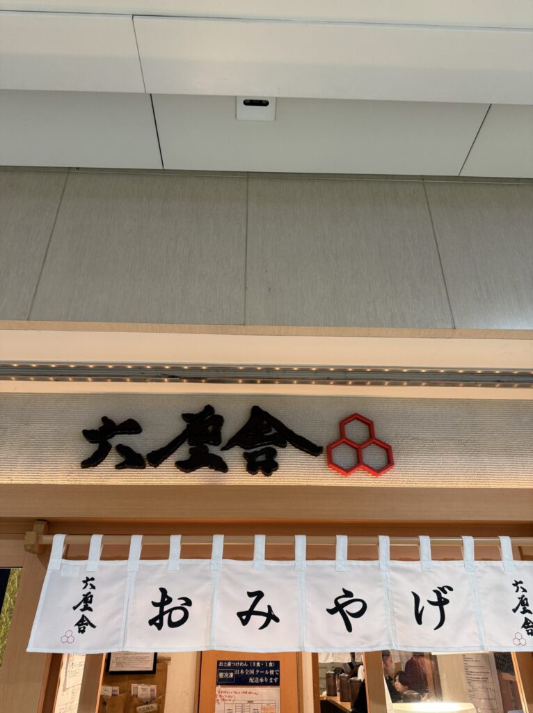 行列の先に見える六厘舎のおみやげ暖簾