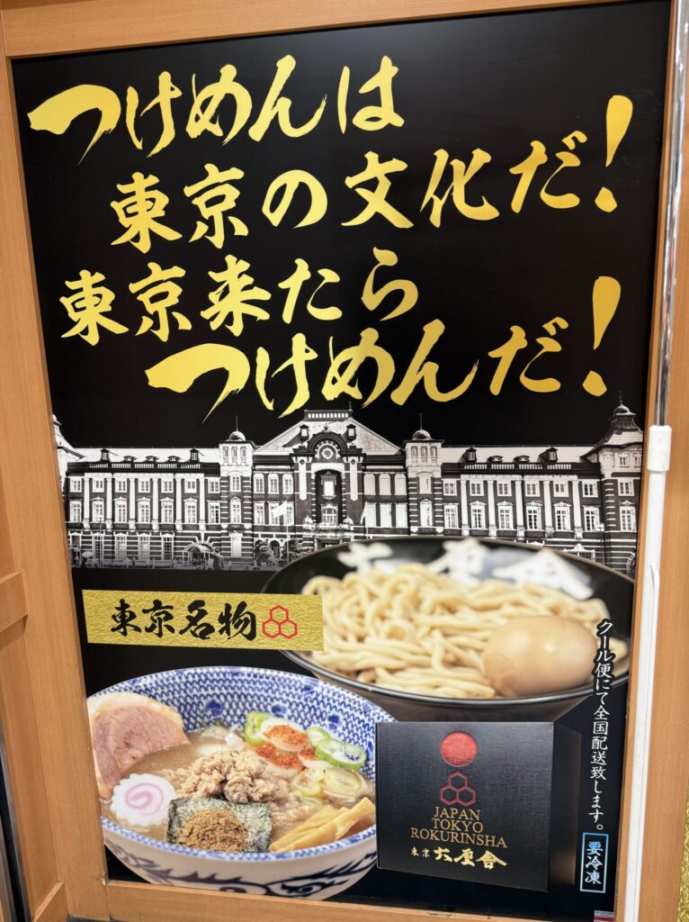 A yellow sign declaring tsukemen as Tokyo's culture with a drawing of Tokyo Station.