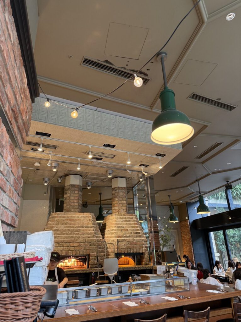 店内の大きなピザ窯とスタッフの様子