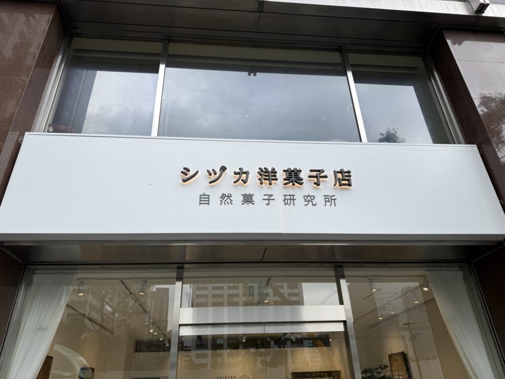 シヅカ洋菓子店 自然菓子研究所の看板とガラス張りのエントランス