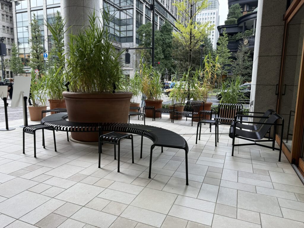 A relaxing terrace space with potted plants and a bench in Marunouchi