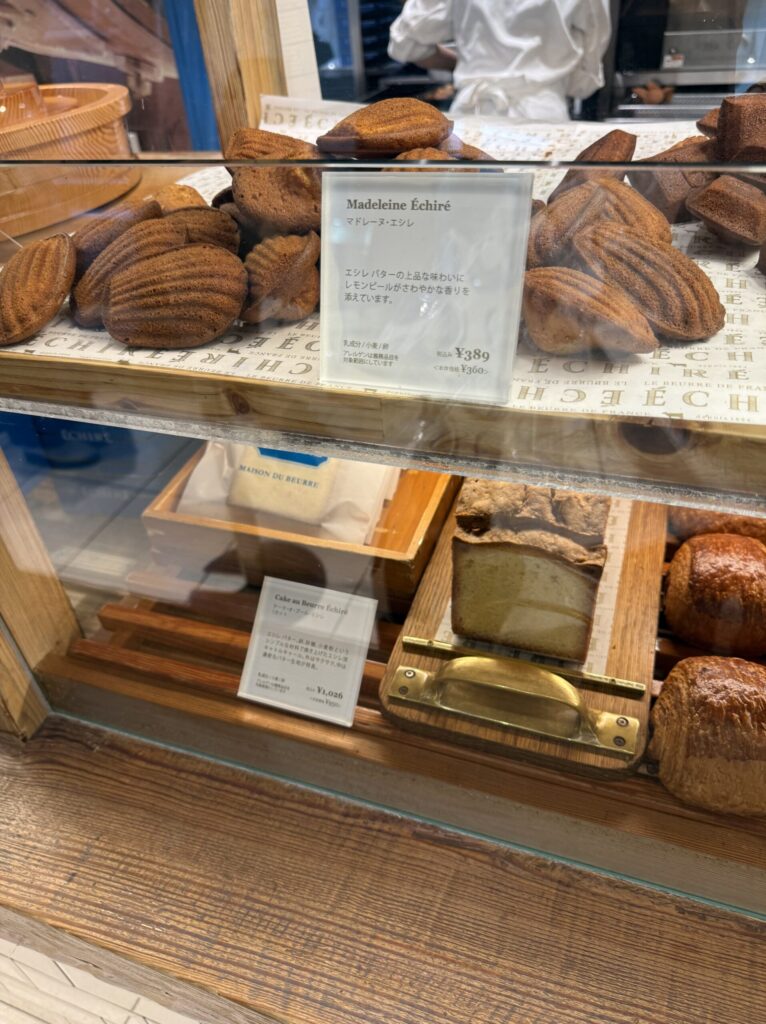 A beautiful array of golden madeleines and baked goods on wooden trays