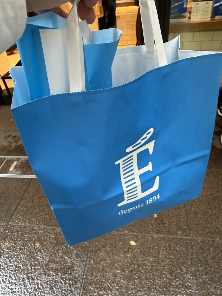 The vibrant Echire blue shopper bag swaying against the stone pavement of Marunouchi