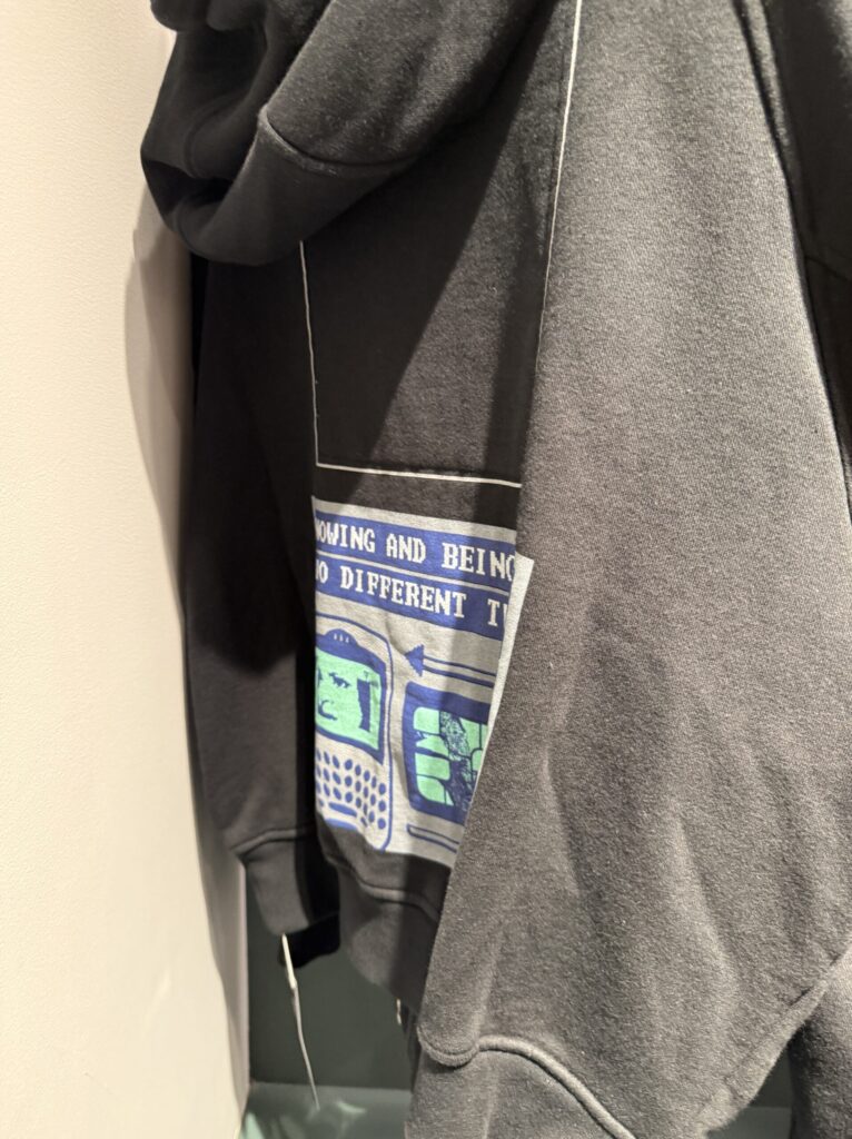 Folded black C.E sweatshirt with blue and green graphics