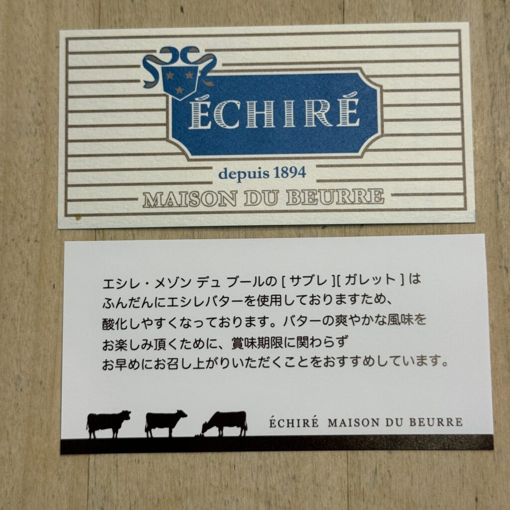 A sophisticated blue and white shop card resting on a wooden table