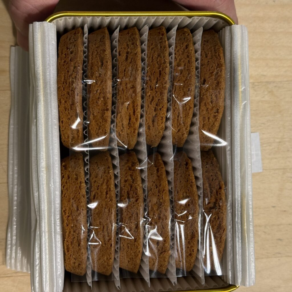 Deep golden brown galettes carefully lined up inside a tin