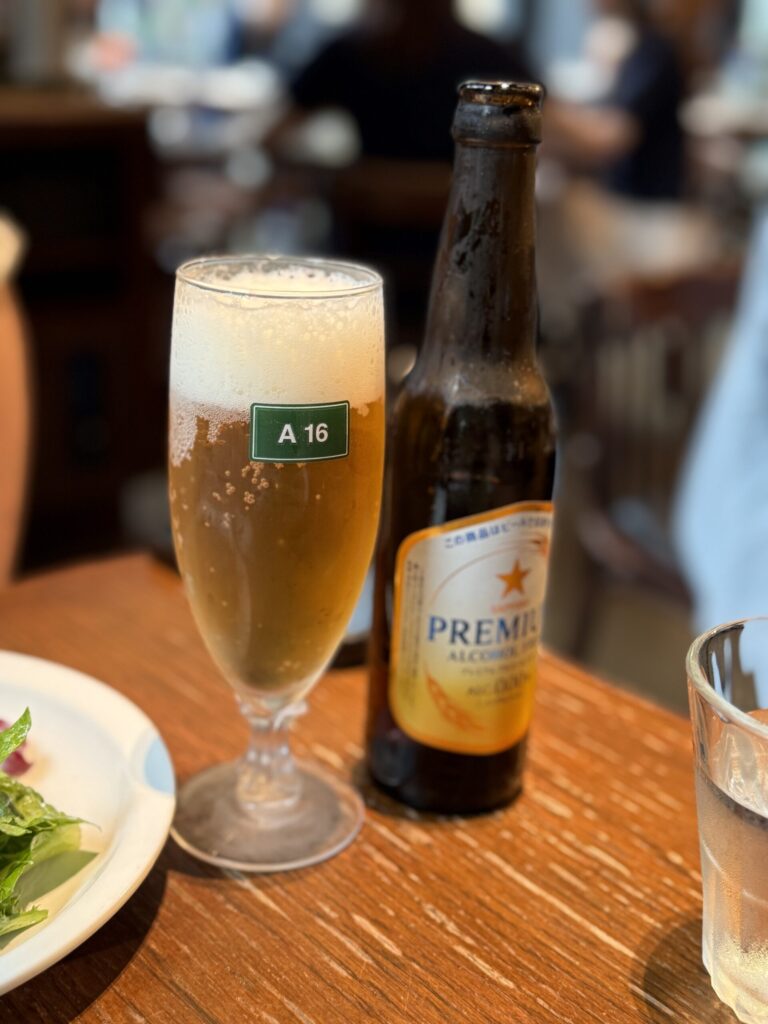 A chilled glass of non-alcoholic beer on a wooden table at A16 TOKYO