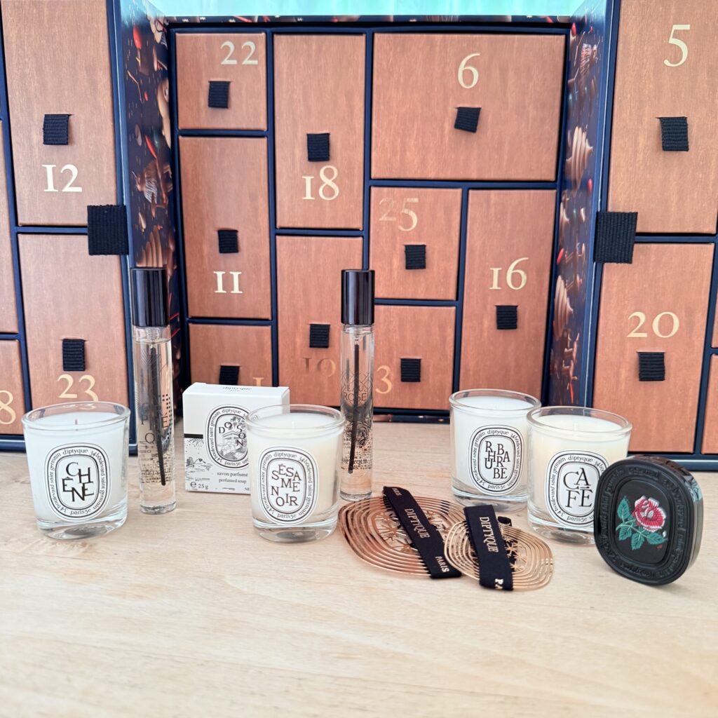 Various diptyque items displayed in front of the opened advent calendar.