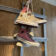 Snakeskin and pink Converse hanging by laces on a rack.